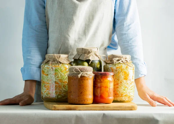 Légumes fermentés ou en conserve, courgettes différentes, carottes, choucroute, concombres dans des pots se tiennent sur le sel contre — Photo