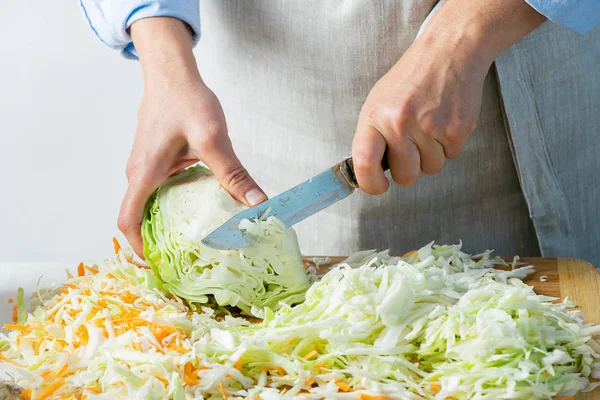 Женщина нарезает свежую органическую капусту для приготовления салата или для соления капусты природным фоном. Вегетарианское питание . — стоковое фото