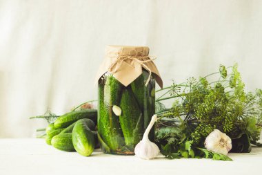 Mayalanmış veya masa üzerinde cam kavanozda salatalık kantinler hafif bir arka plan. Sonbahar hasadının işlenmesi. Konserve gıda