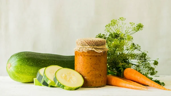Ферментированное консервирование различных овощей цуккини морковь в стеклянных банках на столе светлый фон. Консервы . — стоковое фото