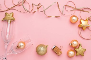 Yeni Yıl veya Noel düz düzeni. Pembe bir arka plan üzerinde şenlikli parlak topları koniser boş şarap bardakları.