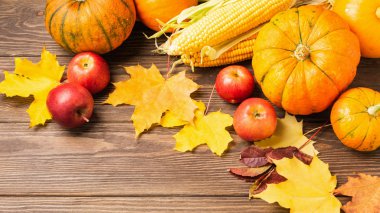 Sonbahar, olgunlaşmış balkabağı, elma, tahtadan arka planda düşmüş sarı yapraklar. Şükran Günü Sonbahar Konsepti.