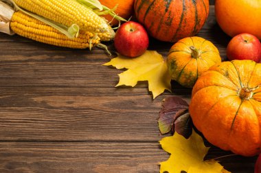 Sonbahar, olgunlaşmış balkabağı, elma, tahtadan arka planda düşmüş sarı yapraklar. Şükran Günü Sonbahar Konsepti.