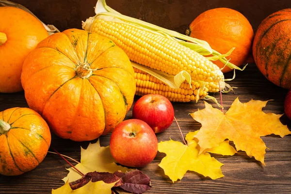 Sonbahar, olgunlaşmış balkabağı, elma, tahtadan arka planda düşmüş sarı yapraklar. Şükran Günü Sonbahar Konsepti.