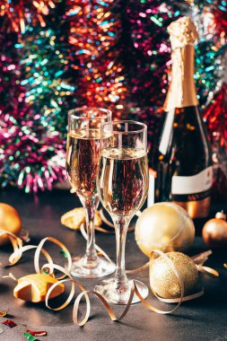 Cam kadehlerde şampanya bir şişe Noel oyuncağı Serpentine yıldızlarının ışıl ışıl arka planı. Yeni yıl kavramı.