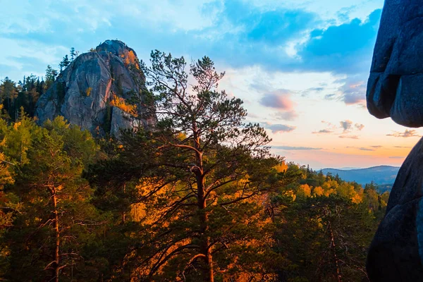 Akşam dağları manzarası. Dağlar batan güneşe karşı ağaçları kayalar. Krasnoyarsk Ulusal Park Sütunları.