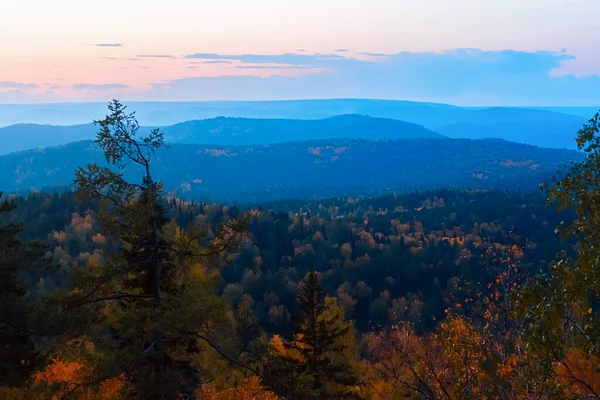 Akşam dağları manzarası. Dağlar batan güneşe karşı ağaçları kayalar. Krasnoyarsk Ulusal Park Sütunları.