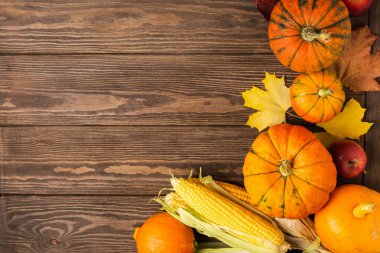 Sonbahar, olgunlaşmış balkabağı, elma, tahtadan arka planda düşmüş sarı yapraklar. Şükran Günü Sonbahar Konsepti.