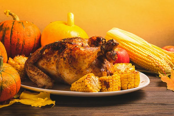 Pavo festivo o pollo horneado por Acción de Gracias un plato blanco y una cosecha de verduras de temporada: manzanas de calabaza de maíz — Foto de Stock