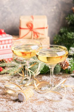 İki kadeh şampanya, şenlikli Noel süslemeli bir masada yakın plan şarap mantarı. Yeni yıl konsepti.