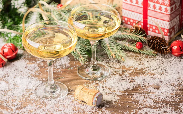 Two glasses of champagne sparkling wine close-up cork on a festive Christmas decorated table. New Year concept.
