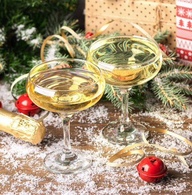 İki kadeh şampanya, şenlikli Noel süslemeli bir masada yakın plan şarap mantarı. Yeni yıl konsepti.