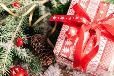 Kırmızı kurdeleli yeni yıl hediyesi Noel ağacı yakın plan. Seçici odaklanma. Bayramlık klasik konsept