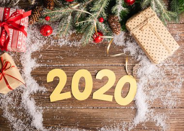 Yılbaşı ağacı oyuncakları 2020 sembollerini sunar. Ahşap bir arka plan. Düz yerleşim tebrik kartı şablonu.