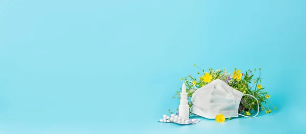 The concept combating preventing seasonal allergies. Fresh flowers medical mask pills drops medicine blue background. — Stock Photo, Image