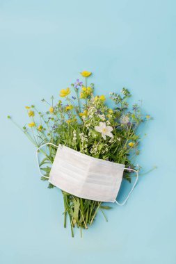 Koruyucu tıbbi maske ve mavi arka planda taze çiçekler. Metin tasarım konsepti sağlığınız için düz bir yerleşim yeri