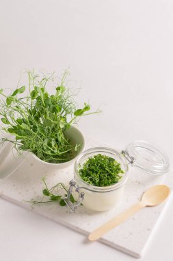 Ekşi süt içeceği ve taze mikro çimenler beyaz mutfak masasında yeşilleniyor..