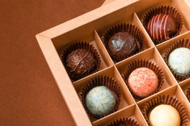 Koyu kahverengi bir arka planda saten bir kurdeleyle çeşitli çikolata malzemelerinden çikolatalı trüf..