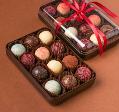 Koyu kahverengi bir arka planda saten bir kurdeleyle çeşitli çikolata malzemelerinden çikolatalı trüf..