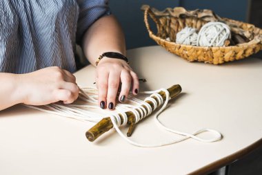 Kadın elleri ev atölyesinde makrome örüyor. Boho yaşam tarzı. Hobi konsepti. Seçici odak yatay çerçevesi.
