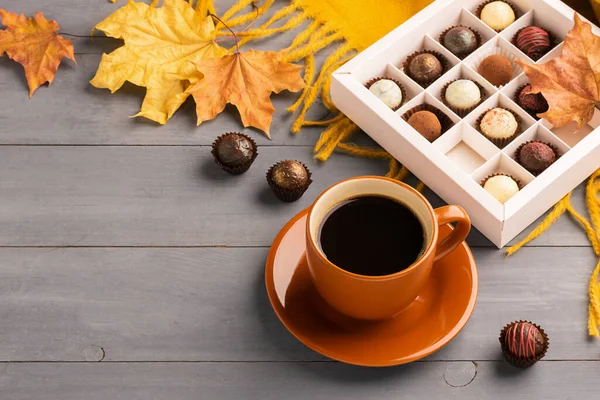 Cup of black coffee box of chocolates on an autumn background. Selective focus. Copy space. Top view flat layout.