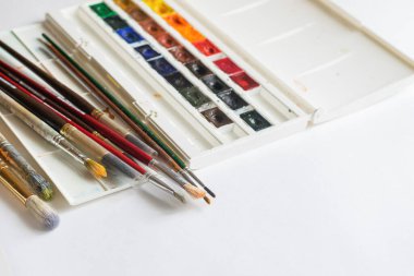 Boya fırçaları beyaz arka plandaki çok renkli suluboya boyalar yarı yalıtımlıdır. Reklam tasarımı metni için yeri olan düz bir düzen. Eğitim Sanatı Yaratıcılık Konsepti