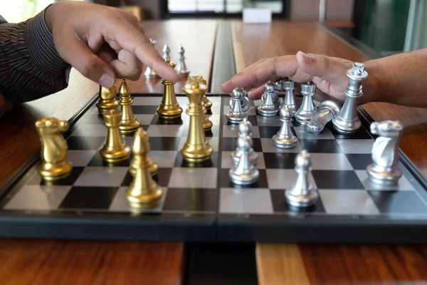 Bir satranç oyunu sırasında bir satranç tahtası üzerinde checkmate ellerin yakın çekim fotoğrafları iş zafer stratejisi kavramı zeka oyunu kazanır.