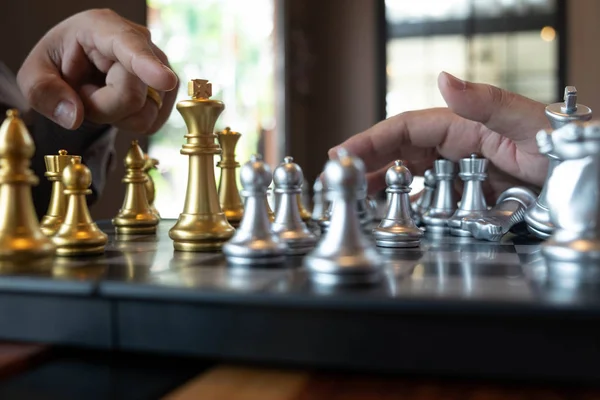 Bir satranç oyunu sırasında bir satranç tahtası üzerinde checkmate ellerin yakın çekim fotoğrafları iş zafer stratejisi kavramı zeka oyunu kazanır.