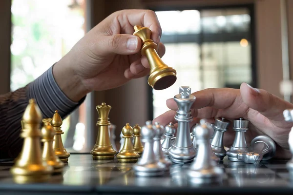 Bir satranç oyunu sırasında bir satranç tahtası üzerinde checkmate ellerin yakın çekim fotoğrafları iş zafer stratejisi kavramı zeka oyunu kazanır.