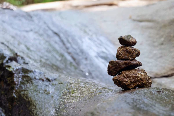 Four stones are arranged vertically and have flowing through the