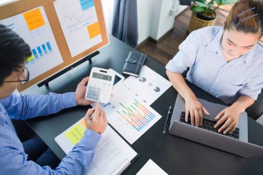 Kazançların sunumu sırasında iş adamları finans tablosuna sunuluyor, iş performans raporuna danışılıyor, rapor verilerine bakılıyor