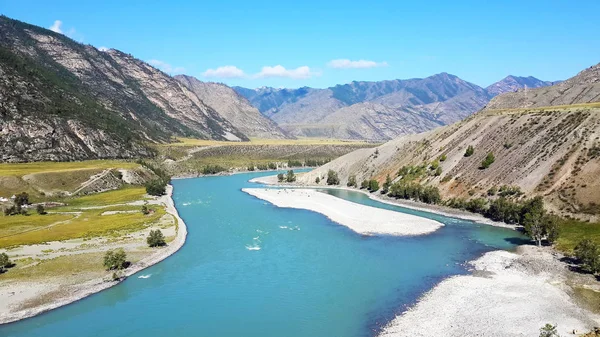 Dağların, denizlerin ve nehirlerin, yeşil çimenlerin büyüleyici doğası. Altay. Mavi gökyüzüne karşı, kumlu plaj.