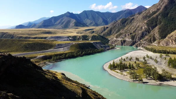 Dağların, denizlerin ve nehirlerin, yeşil çimenlerin büyüleyici doğası. Altay. Mavi gökyüzüne karşı, kumlu plaj.