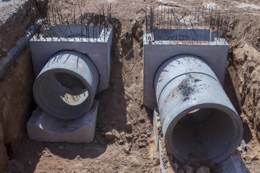 Farklı çap ve gri beton yüzük Wells'le sokakta yalan