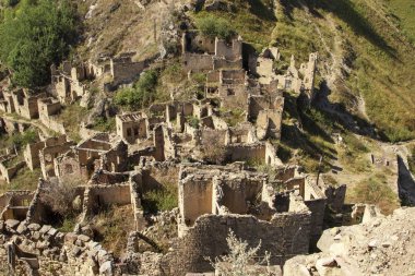 Şehir - hayalet, Dağıstan, Rusya - 1 Eylül 2019: Antik kalıntılar şehri, şehir - hayalet, arka plan kayalar üzerinde yeşil bitki örtüsü ile dağlık alan, mavi gökyüzü ve yeşil orman