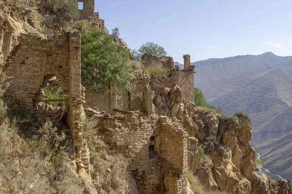 City - ghost, Dagestan, Russian - 1 SEPTEMBER, 2019: City of ancient ruins, city - ghost, mountainous area with green vegetation on background rocks, of blue sky and green forest