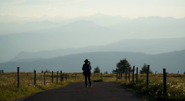 Genç bayan yürüyüşçü Siusi Alpleri 'nin güzel manzarasında duruyor ve muhteşem Dolomite dağlarının tadını çıkarıyor.