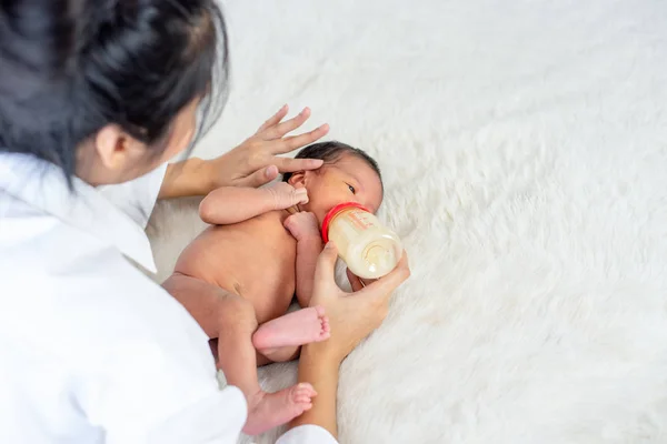 Asiatico Madre Dare Latte Alimentazione Con Bottiglia Piccolo Neonato Bianco — Foto Stock