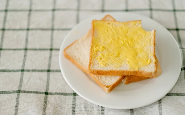 Pão Com Manteiga São Colocados Prato Branco Sobre Roupas Mesa — Fotografia de Stock