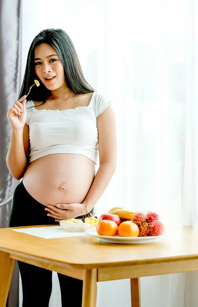 Asiatische Schöne Schwangere Frau Stehen Und Essen Einige Früchte Vor — Stockfoto