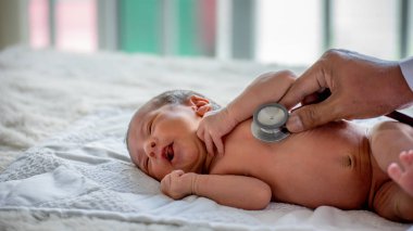Doktor ellerinin yumuşak bulanıklığı yenidoğan bebek sağlığını kontrol etmek ve ona dikkat etmek veya hastalık veya bozukluğu tedavi etmek için stetoskop kullanın.