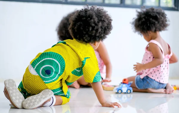 Menino Africano Olhar Para Duas Meninas Jogar Brinquedos Juntos Olhar — Fotografia de Stock