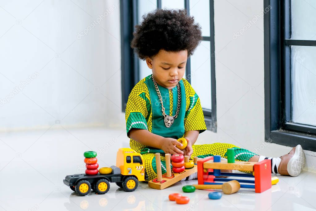 African young boy has fun with playing various type of toys.