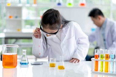 Güzel küçük kız laboratuvarda gündüz vakti kimyasal maddeleri incelemeyi sever. Çocuklar için iyi uygulama ve bilim eğitimi kavramı öğrenmelerini destekliyor.