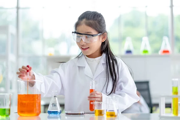 可爱的小女孩喜欢和兴奋地在实验室里用日光浴水滴来检测颜色化学物 为儿童提供的良好做法和科学教育概念支持了他们的学习 — 图库照片