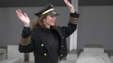 Güzel kadın pilot havaalanında yürüyüş ve dans ediyor