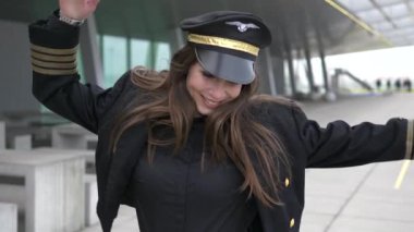 Güzel kadın pilot havaalanında yürüyüş ve dans ediyor