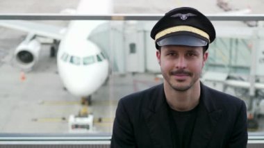 Genç erkek pilot havaalanında poz veriyor.