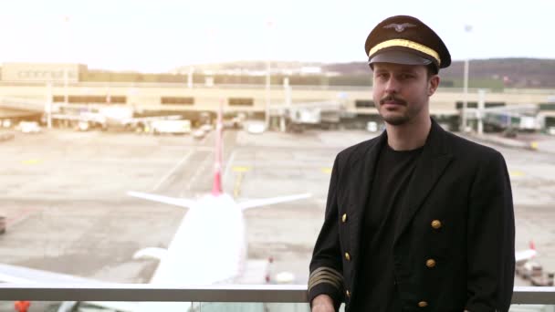若い男性パイロットは空港でポーズをとっています — ストック動画