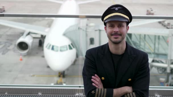 若い男性パイロットは空港でポーズをとっています — ストック動画